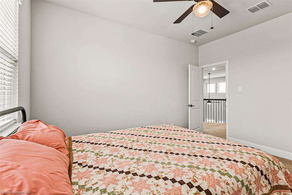 904 Vineyard Way Forney, TX 75126 - Photo 33 of 38 a bedroom with a large bed and a chandelier