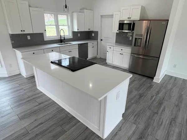 a kitchen with a sink a refrigerator a microwave and cabinets