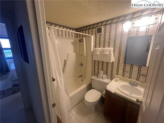 a bathroom with a sink a mirror a toilet and shower