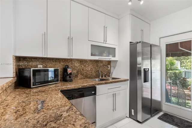 a kitchen with stainless steel appliances granite countertop a refrigerator stove and sink