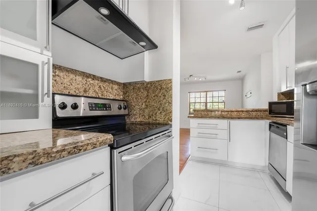 a kitchen with stainless steel appliances granite countertop a stove and a refrigerator