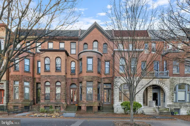 a living room with furniture a fireplace and a chandelier