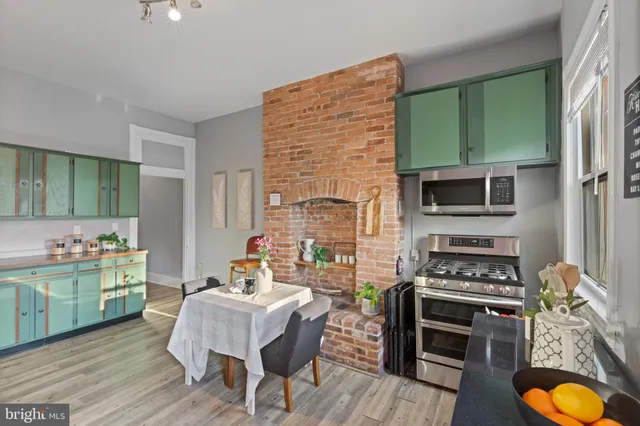 a kitchen with kitchen island a counter top space a sink stainless steel appliances and cabinets