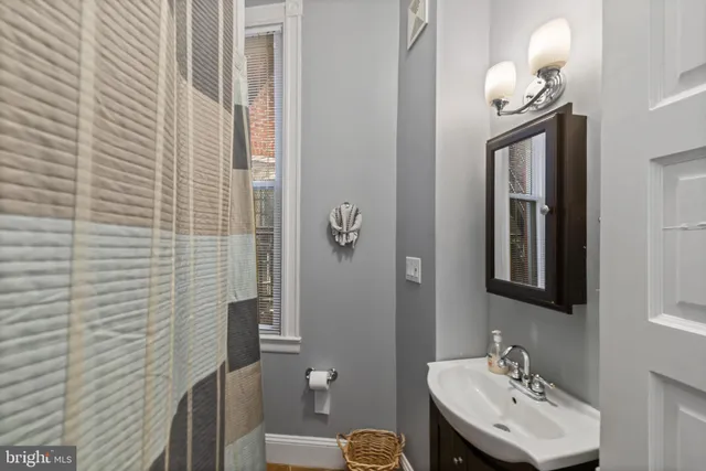 a view of an empty room with chandelier fan and windows