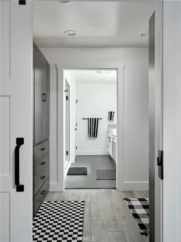 a view of a hallway with wooden floor and a living room