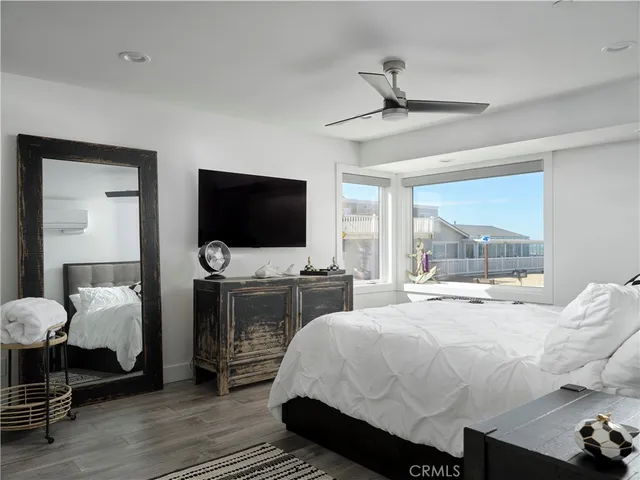 a bedroom with a bed and a flat tv screen on dresser