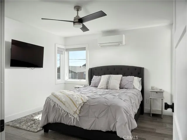 a bedroom with a bed tv and a window