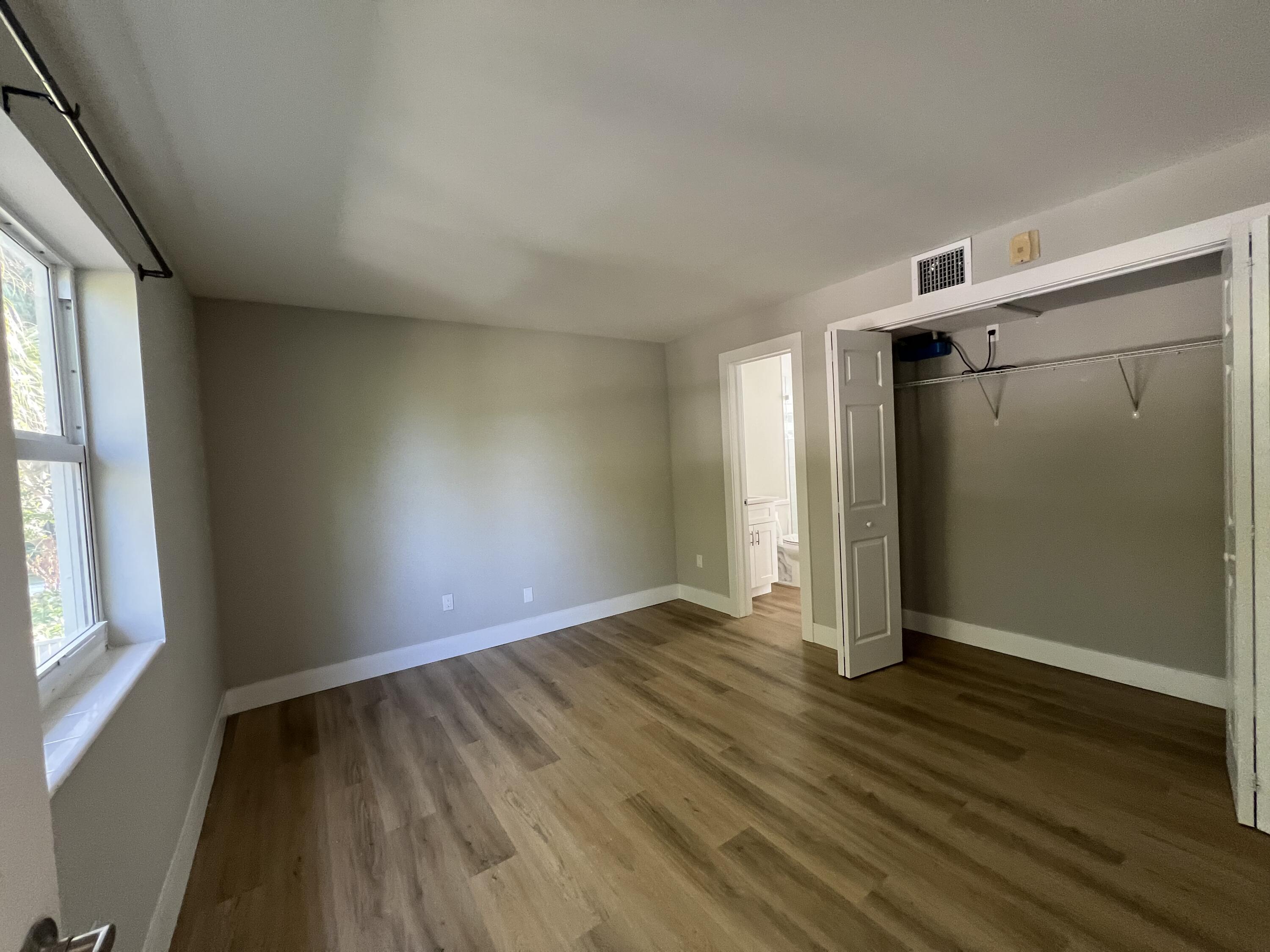 6600 North Ocean Boulevard, Unit 16 Ocean Ridge, FL 33435 - Photo 11 of 21 an empty room with wooden floor and windows