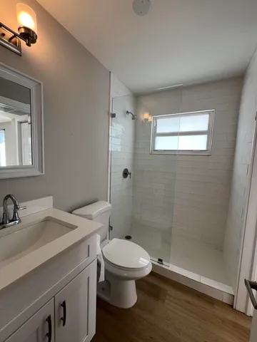 a bathroom with a sink a toilet and shower