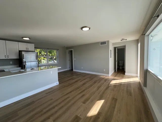 a view of a kitchen with wooden floor and electronic appliances