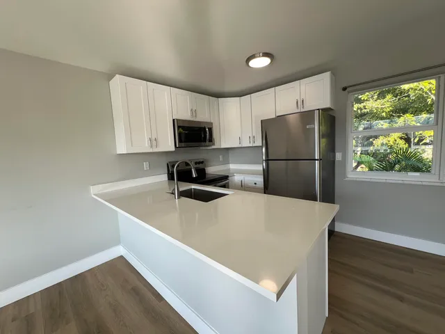 a kitchen with a refrigerator a stove top oven a refrigerator and a window