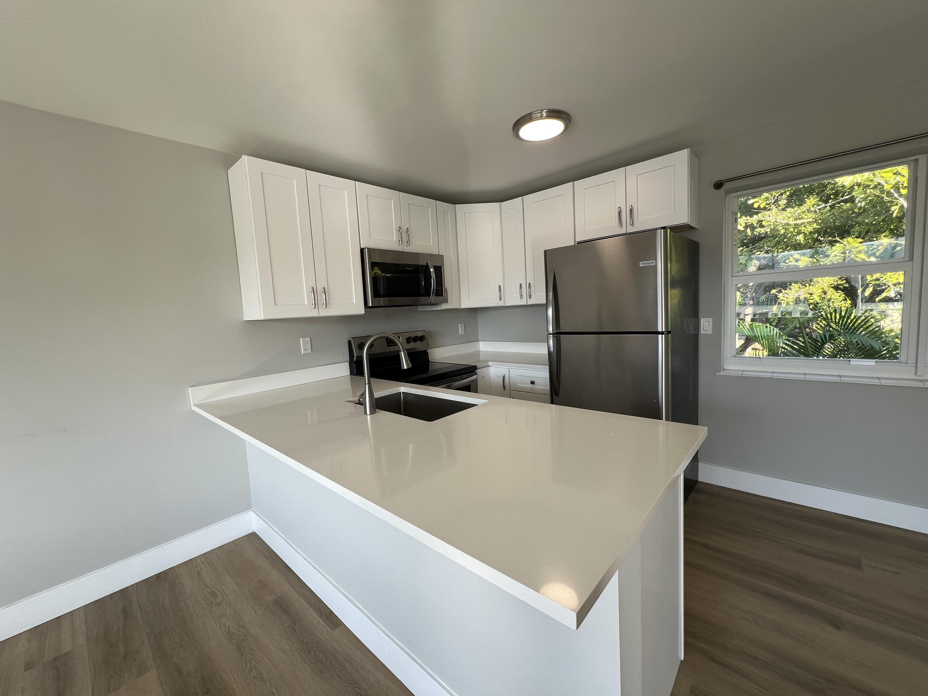 6600 North Ocean Boulevard, Unit 16 Ocean Ridge, FL 33435 - Photo 6 of 21 a kitchen with a refrigerator a stove top oven a refrigerator and a window