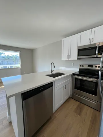 a kitchen with stainless steel appliances a sink stove and microwave