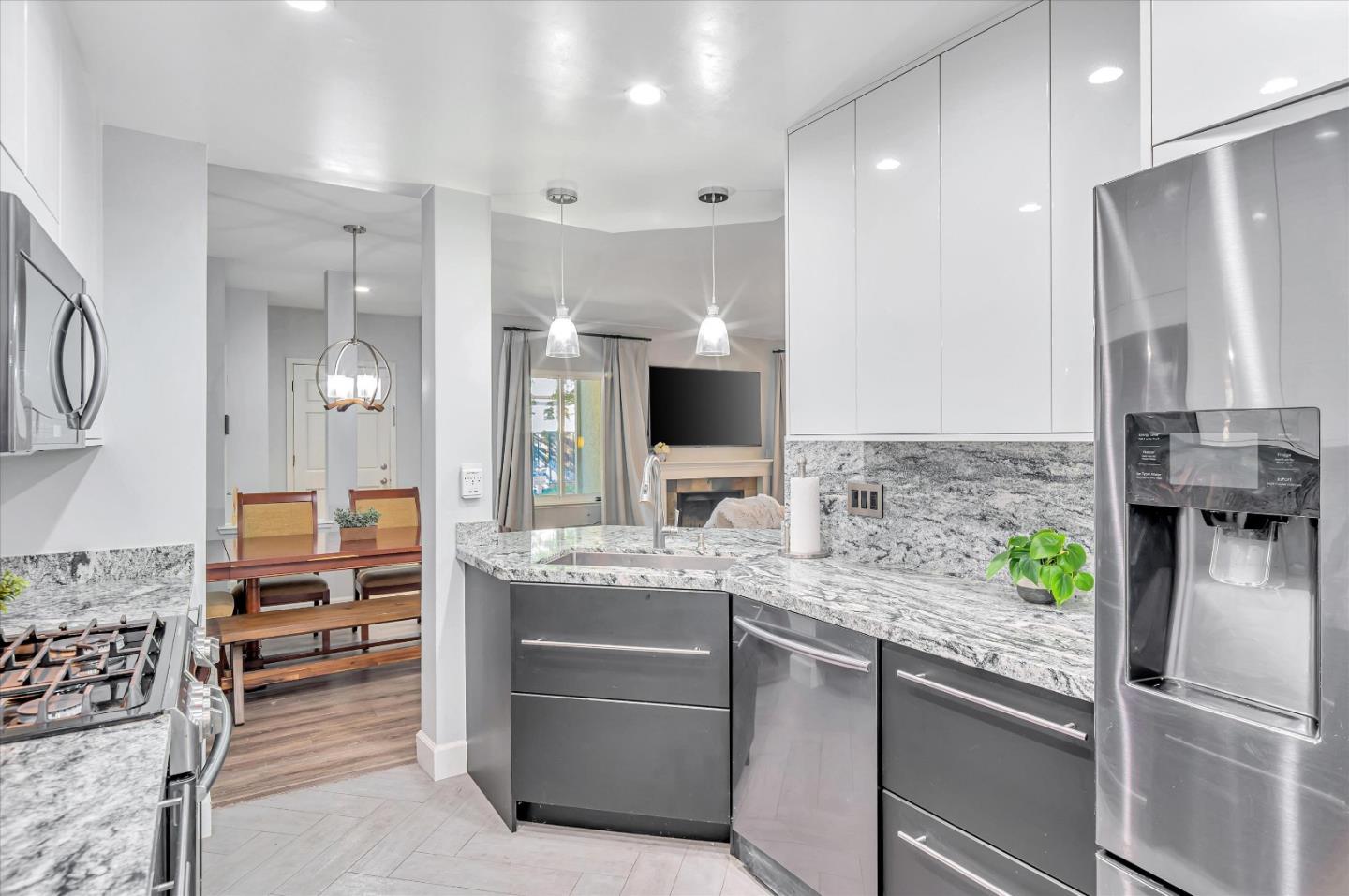a kitchen with kitchen island granite countertop a refrigerator and a sink