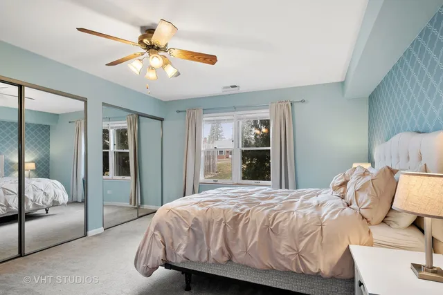 a bedroom with a large bed and a chandelier