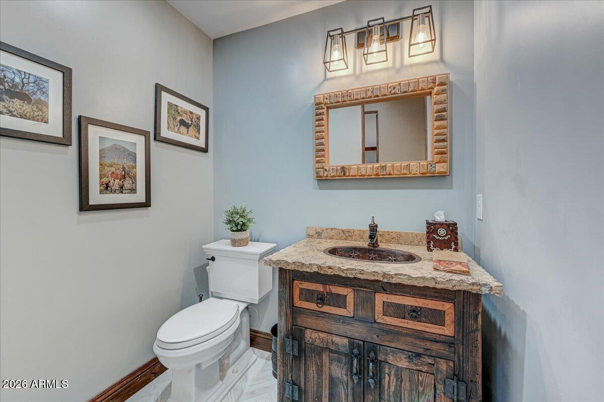 8343 East Spanish Boot Road Carefree, AZ 85377 - Photo 40 of 71 a bathroom with a toilet a sink and mirror