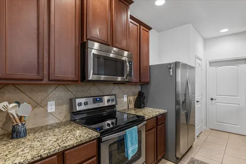 a kitchen with stainless steel appliances granite countertop a stove microwave refrigerator and sink