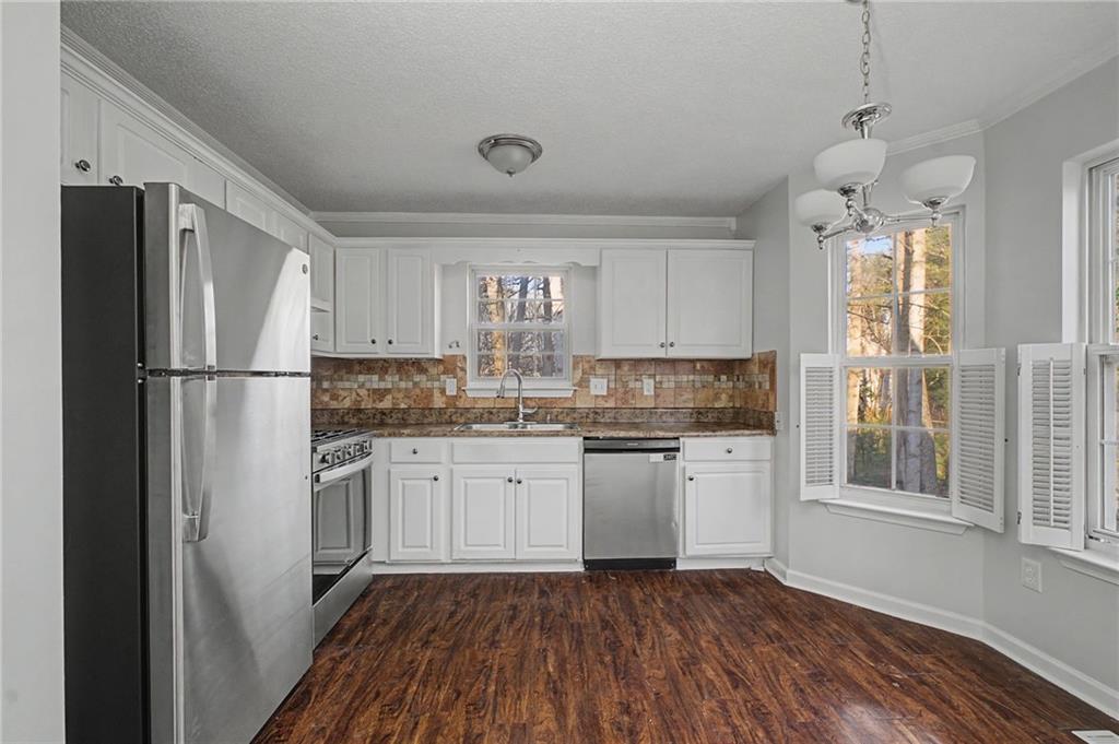 4244 Akins Ridge Lane Powder Springs, GA 30127 - Photo 14 of 37 a kitchen with granite countertop stainless steel appliances a refrigerator sink and microwave