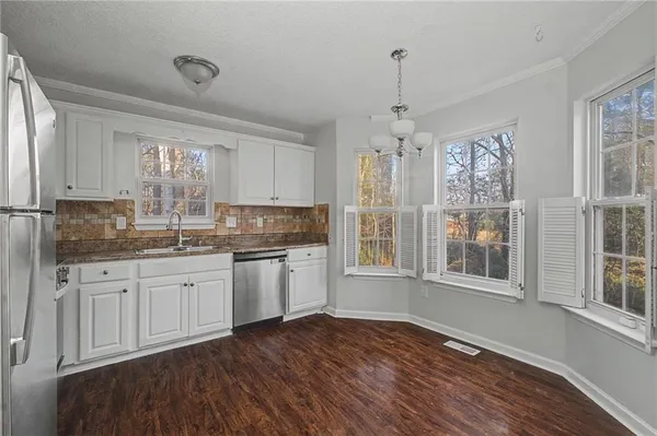 a kitchen with stainless steel appliances granite countertop a refrigerator sink and stove