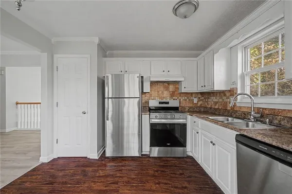 a kitchen with cabinets stainless steel appliances and a counter space