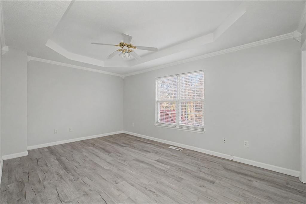 4244 Akins Ridge Lane Powder Springs, GA 30127 - Photo 18 of 37 an empty room with wooden floor ceiling fan and windows
