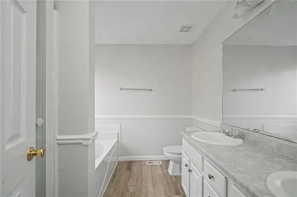 a bathroom with a granite countertop sink a toilet and a large mirror