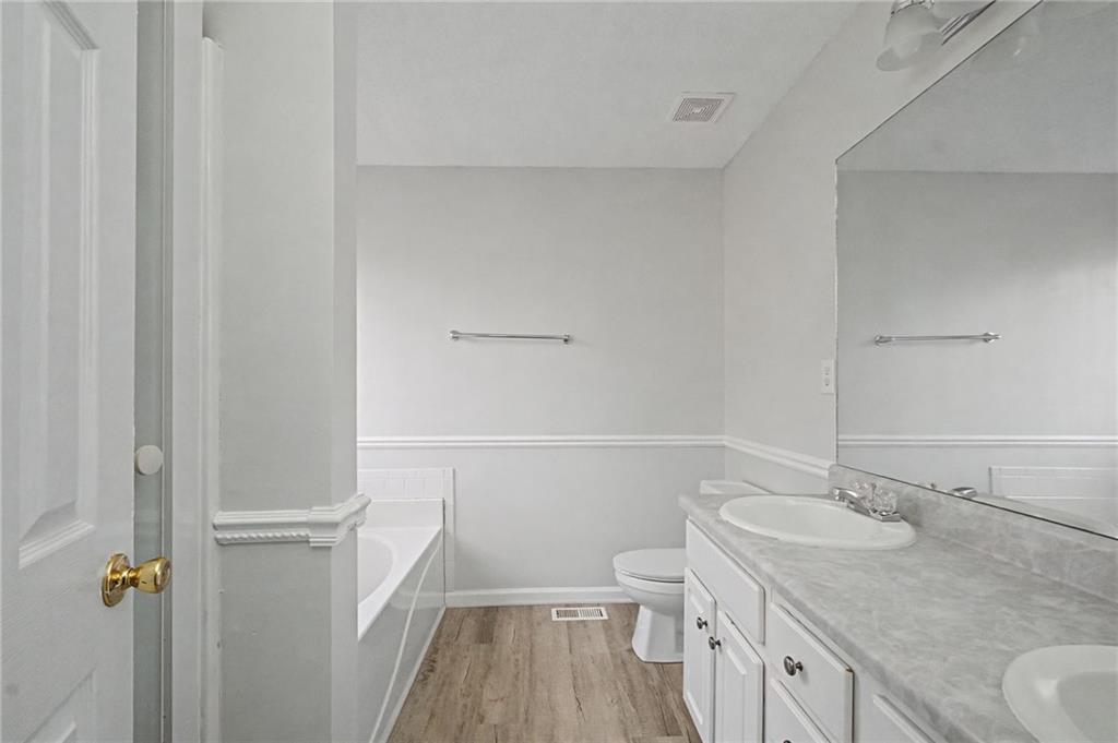 4244 Akins Ridge Lane Powder Springs, GA 30127 - Photo 23 of 37 a bathroom with a granite countertop sink toilet and shower