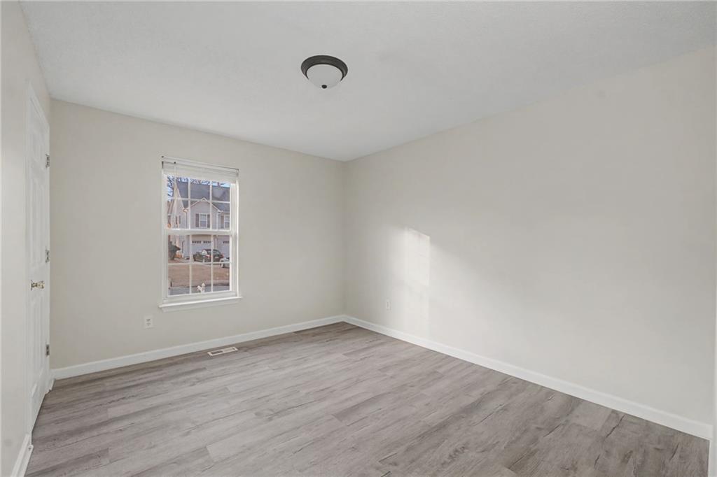 4244 Akins Ridge Lane Powder Springs, GA 30127 - Photo 27 of 37 an empty room with wooden floor and windows