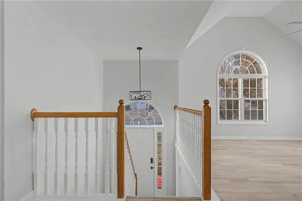 a view of a hallway with wooden floor and stairs