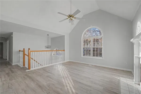 a view of a hallway with wooden floor and a chandelier