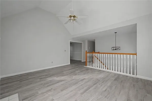 an empty room with wooden floor fireplace and windows