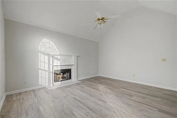 wooden floor fireplace and windows in an empty room