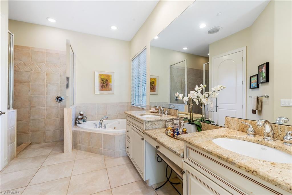 4852 West Blvd Court Naples, FL 34103 - Photo 11 of 18 a bathroom with a granite countertop sink a large mirror and shower