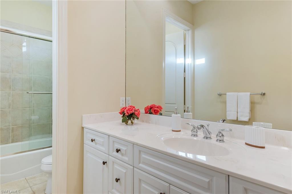 4852 West Blvd Court Naples, FL 34103 - Photo 13 of 18 a bathroom with a sink and a mirror