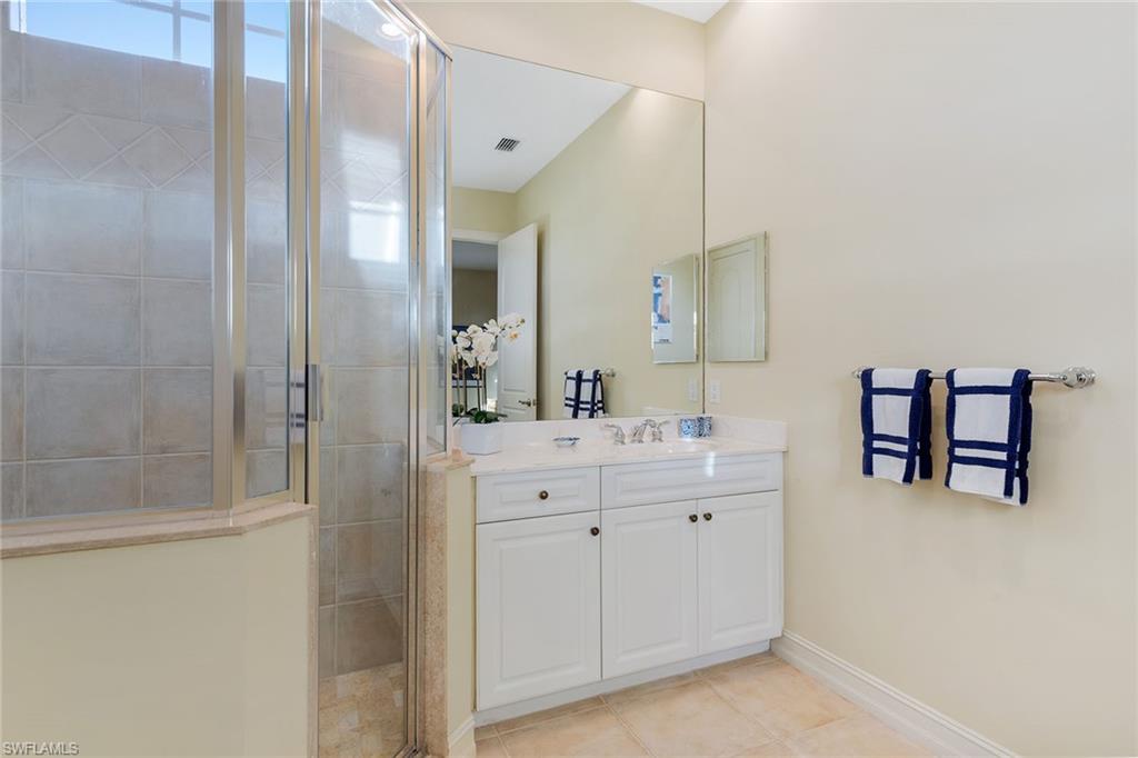 4852 West Blvd Court Naples, FL 34103 - Photo 15 of 18 a spacious bathroom with a double vanity sink and a mirror