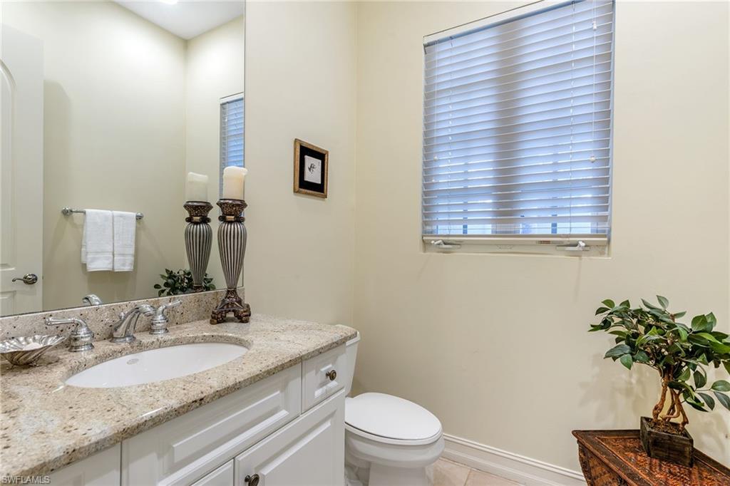 4852 West Blvd Court Naples, FL 34103 - Photo 17 of 18 a bathroom with a granite countertop sink toilet a mirror and shower