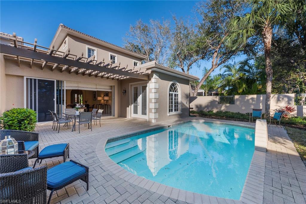 4852 West Blvd Court Naples, FL 34103 - Photo 2 of 18 a view of a swimming pool with outdoor seating