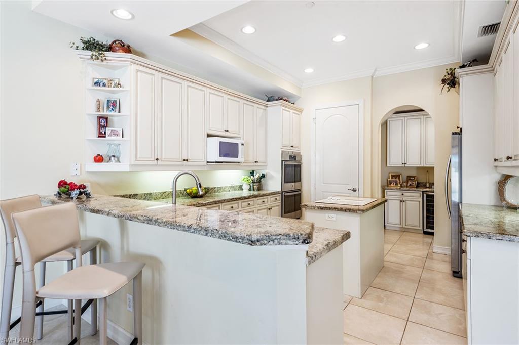 4852 West Blvd Court Naples, FL 34103 - Photo 6 of 18 a kitchen with stainless steel appliances granite countertop a sink and a refrigerator