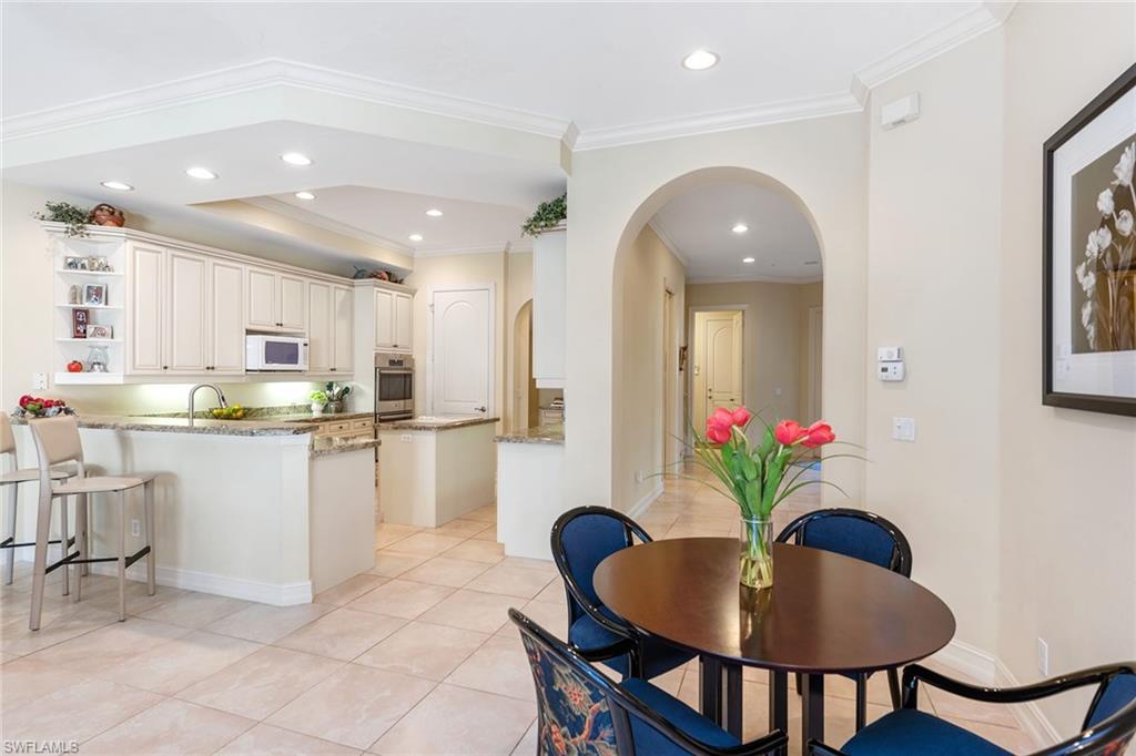 4852 West Blvd Court Naples, FL 34103 - Photo 7 of 18 a kitchen with white cabinets and stainless steel appliances