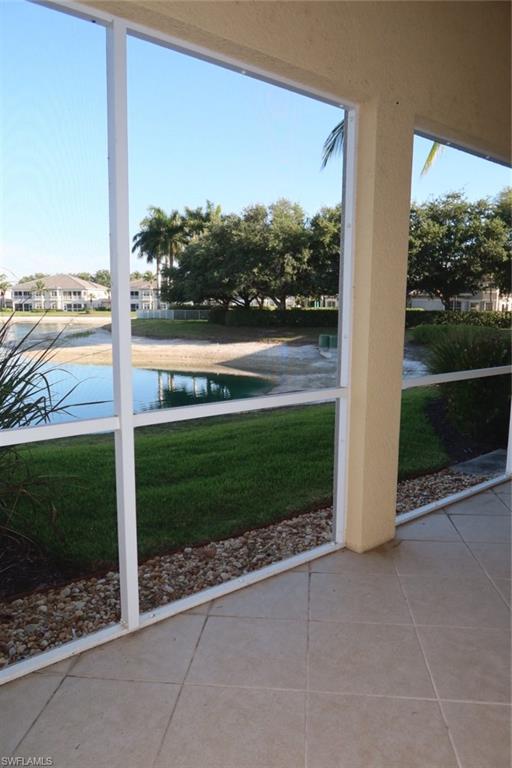 7168 Lemuria Circle, Unit 1701 Naples, FL 34109 - Photo 2 of 39 Screened patio with tile flooring and a water feature