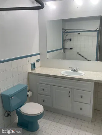 a bathroom with a granite countertop toilet sink and mirror