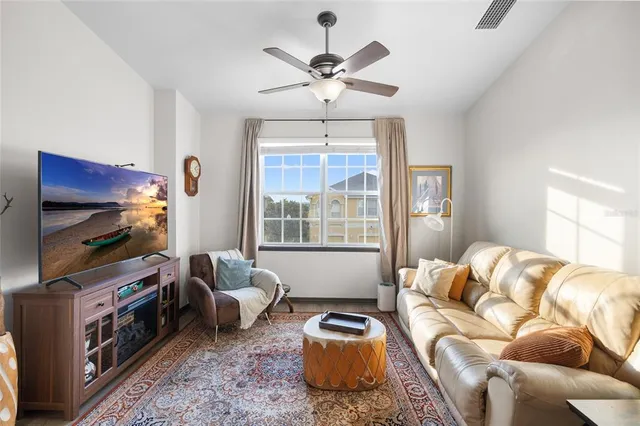 a living room with furniture a flat screen tv and a window
