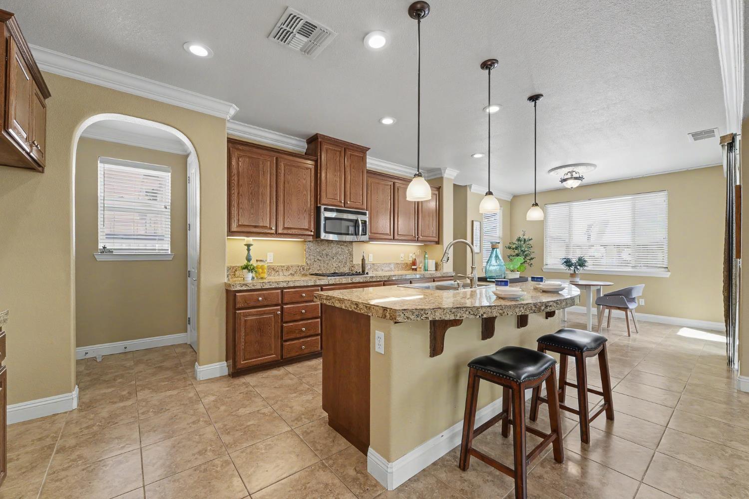 1223 East Springer Drive Turlock, CA 95382 - Photo 15 of 48 a kitchen with kitchen island granite countertop a stove a sink a oven and a refrigerator
