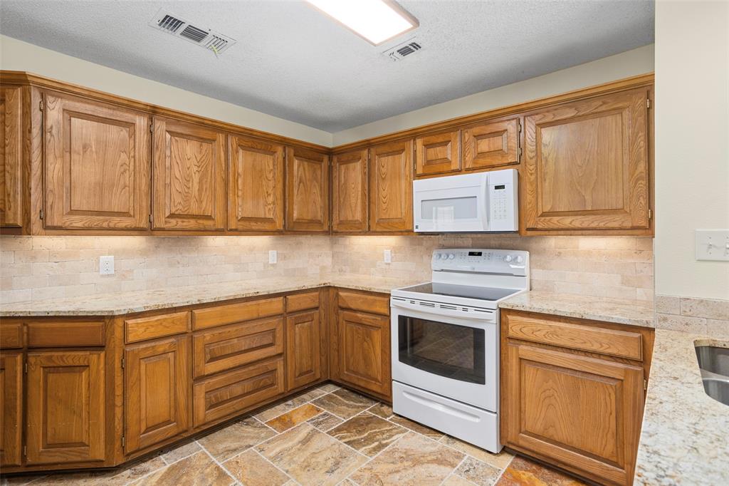5522 Wedgefield Road Granbury, TX 76049 - Photo 9 of 22 a kitchen with cabinets appliances and a counter space