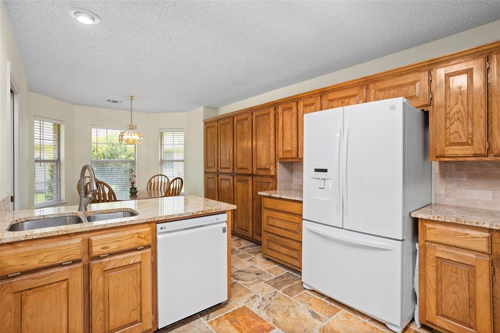 5522 Wedgefield Road Granbury, TX 76049 - Photo 10 of 22 a kitchen with white cabinets and refrigerator