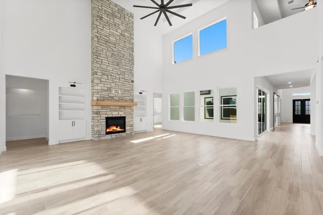 a view of an empty room with a fireplace and a window