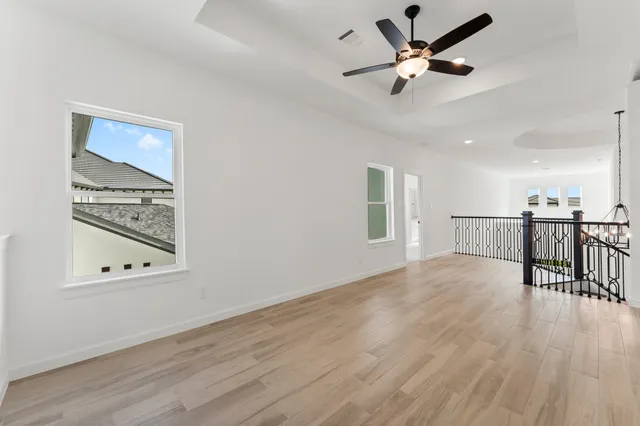 an empty room with a ceiling fan and window