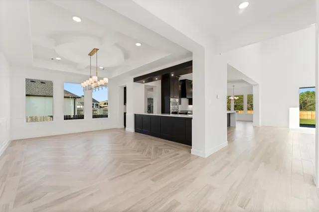 a view of a livingroom with a chandelier fan and windows
