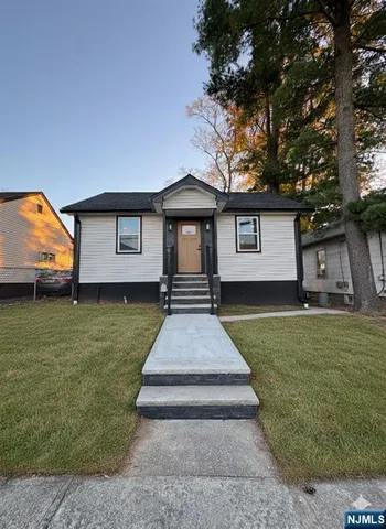 a front view of a house with a yard and trees