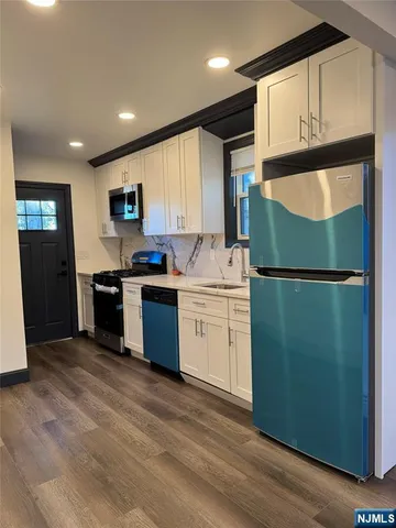 a kitchen with a sink a refrigerator and cabinets